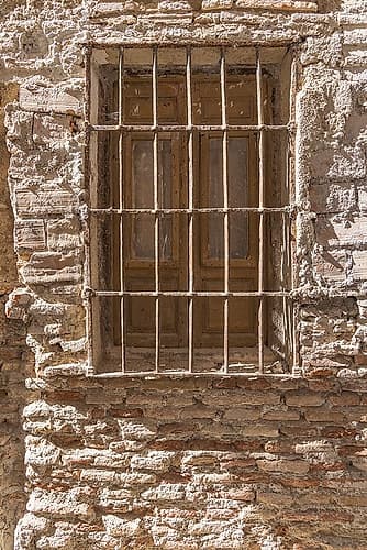 Albaicin, Province of Granada, Andalusia, Spain. Rusting barred window on ancient brick building. Art Print